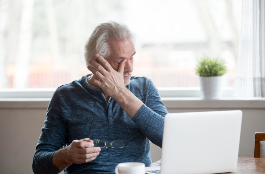 Senior man rubbing his eyes due to dry eyes.