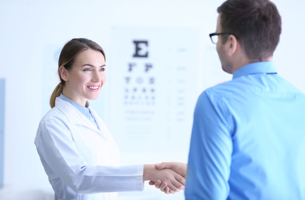 A man in an optometry clinic shaking hands with his female optometrist